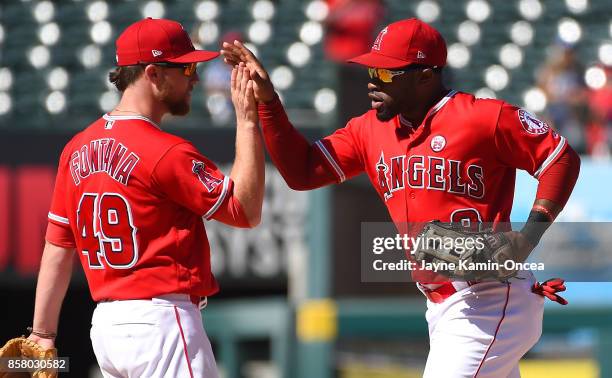 Nolan Fontana and Eric Young Jr. #8 of the Los Angeles Angels of Anaheim high five after the game against the Seattle Mariners at Angel Stadium of...