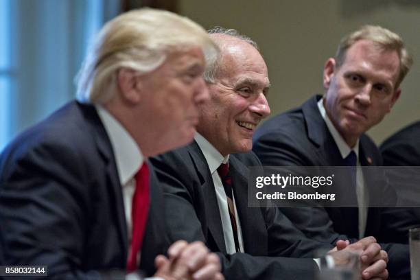 John Kelly, White House chief of staff, center, smiles as U.S. President Donald Trump, left, speaks during a briefing with senior military leaders in...