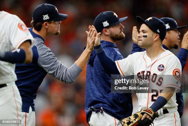 Jose Altuve of the Houston Astros high fives Tyler Clippard after defeating the Boston Red Sox 8-2 to win game one of the American League Division...