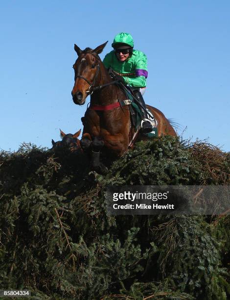 Grand National winner Mon Mome with jockey Liam Treadwell jumps the open ditch on their way to victory during the John Smiths Grand National at...