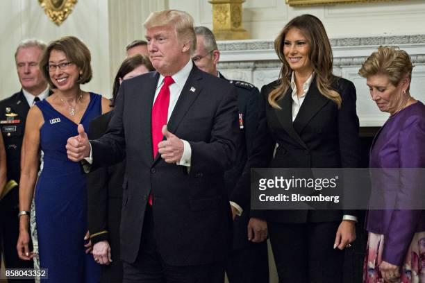 President Donald Trump, center left, gives a thumbs up next to U.S. First Lady Melania Trump, center right, during an official photograph with senior...