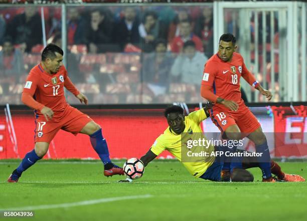 Chile's Gary Medel and Gonzalo Jara vie for the ball with Ecuador's Roberto Ordonez during their 2018 World Cup qualifier football match in Santiago...
