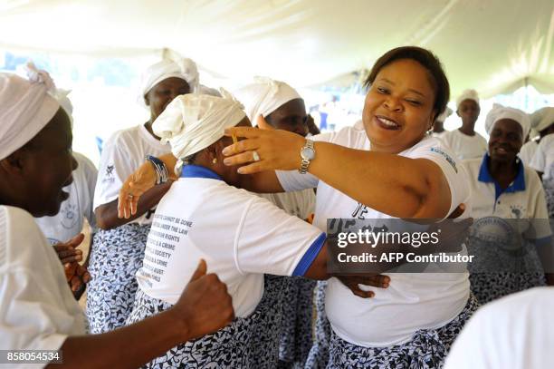 Nobel peace laureate Leymah Gbowee , head of the Women in Peacebuilding Network , greets members of the group in Monrovia on October 5, 2017. Dressed...