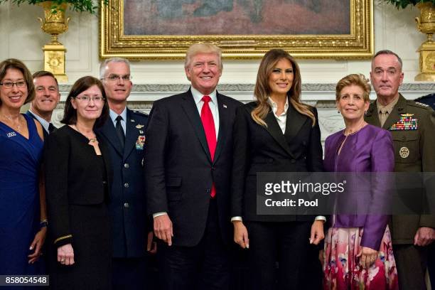 President Donald Trump and first lady Melania Trump pose for pictures with senior military leaders and spouses, including including Gen. Joseph...