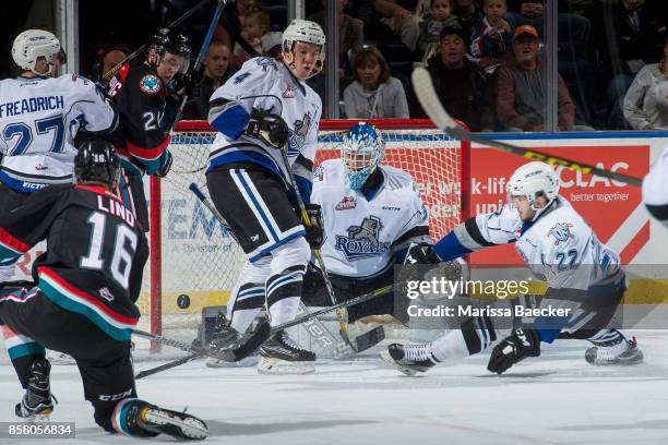 Yan Khomenko tries to block a shot as Griffen Outhouse of the Victoria Royals misses a save on a shot by Kole Lind of the Kelowna Rockets during the...