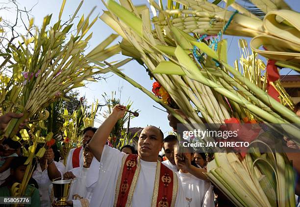 Roman Catholic priest blesses with holy water palm during the Palm Sunday in Manila on April 5, 2008. The Palm Sunday mark the start of the lenten...