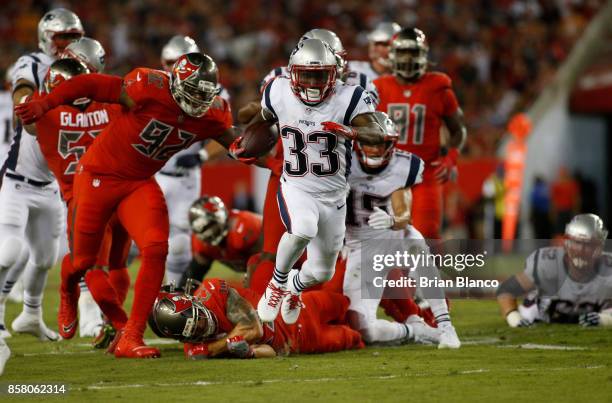 Running back Dion Lewis of the New England Patriots slips tackles from free safety Chris Conte of the Tampa Bay Buccaneers and defensive end William...