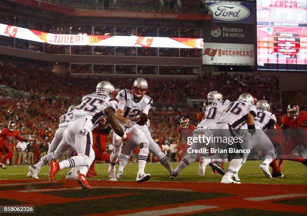 Quarterback Tom Brady of the New England Patriots hands off to running back Mike Gillislee during the first quarter of an NFL football game against...