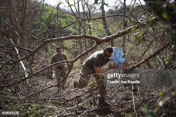 Army 1st Special Force Command SFC Antonio Santini makes his way through downed trees as he helps deliver food and water to hurricane survivors in...