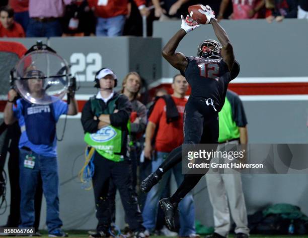Stephen Louis of the North Carolina State Wolfpack makes a leaping catch against the Louisville Cardinals during the game at Carter Finley Stadium on...
