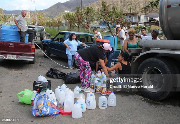 Residents line up to collect water from a tanker parked next to the road in Naranjito with supplies for the residents as part of the relief efforts...