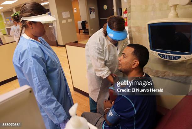 From left, nurses Janiabel Fuentes and Enid Acevedo treat patient Anibal Rosario at Fresenius Kidney Care in Naranjito in the aftermath of Hurricane...