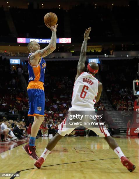 Nick Minnerath of Shanghai Sharks shoots a three point shot defended by Bobby Brown of Houston Rockets in the second half at Toyota Center on October...