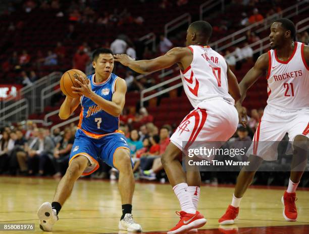 Tang Zihao of Shanghai Sharks controls the ball defended by Isaiah Taylor of Houston Rockets and Chinanu Onuaku in the second half at Toyota Center...