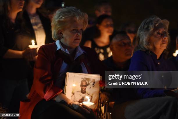 Las Vegas Mayor Carolyn Goodman holds a photo of police officer Charleston Hartfield at his memorial after he was killed on October 1, 2017 when a...