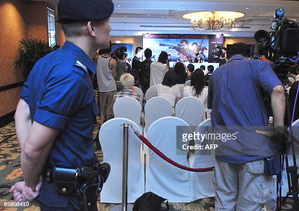 Security personel attend the press conference for Hong Kong entertainer Edison Chen's movie "The Sniper" in Singapore on April 5, 2009. Chen saw his...