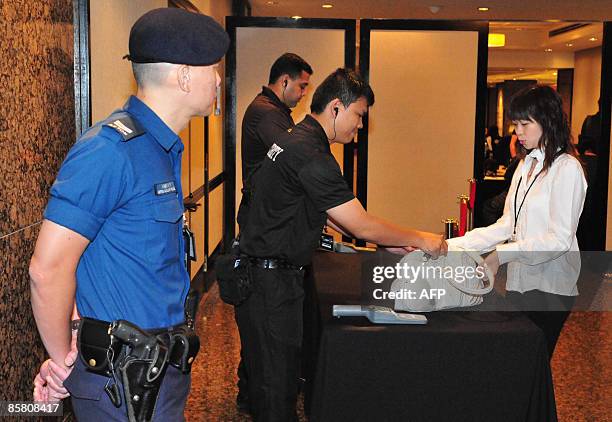 Security personel check the bags of people attending the press conference for Hong Kong entertainer Edison Chen's movie "The Sniper" in Singapore on...