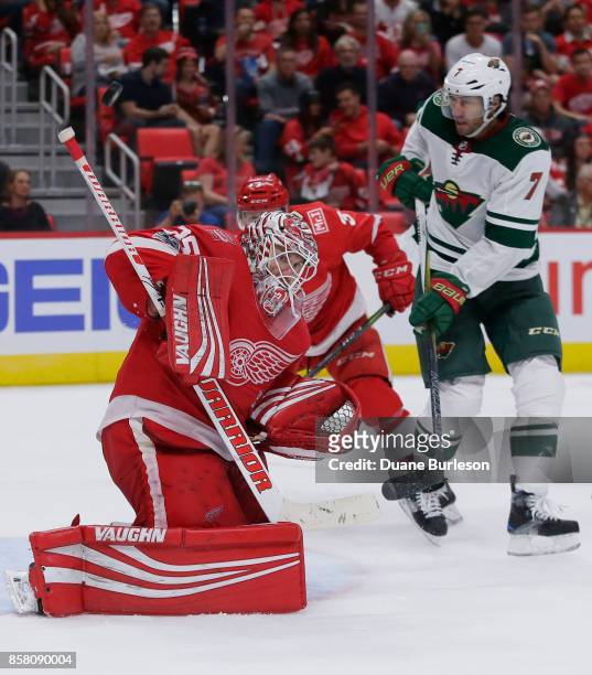 Jimmy Howard of the Detroit Red Wings deflects a shot as Matt Cullen of the Minnesota Wild works in front of the net during the third period at...
