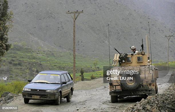 Pakistan-Afghanistan-US-unrest-military,FOCUS BY CHARLOTTE MCDONALD-GIBSON A civilian car drives past a US Army humvee guarding a road during a...