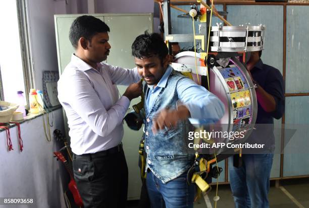 This picture taken on July 23, 2017 shows Indian singer and songwriter Gladson Peter removing his musical rig after a performance in Mumbai. The...