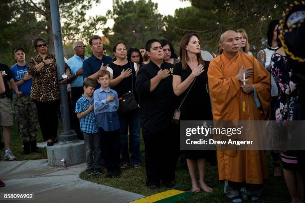 Members of the community stand for Pledge of Allegiance during a vigil for Las Vegas Metropolitan Police Department Officer Charleston Hartfield at...