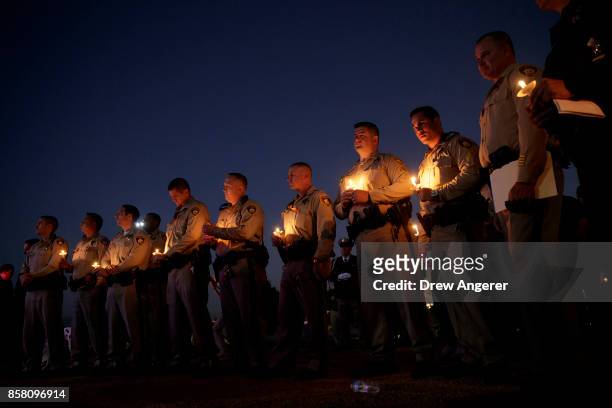 Police officer colleagues of Las Vegas Metropolitan Police Department Officer Charleston Hartfield hold candles during a vigil for Hartfield at...