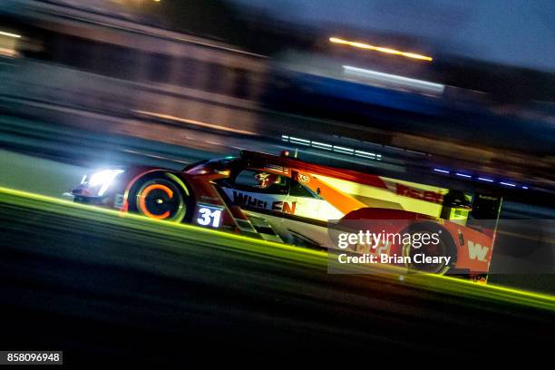 The Cadillac DPi of Dane Cameron, Eric Curran, and Michael Conway, of Great Britain, races on the track during night practice at Road Atlanta on...