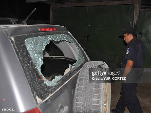 Costa Rican police officer inspects the damages caused by gunfire in the car used by AFP photographer Yuri Cortez and local photographer Carlos...