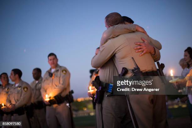 Sgt. Ryan Fryman, who was on the scene of the shooting on Sunday night, hugs a fellow officer during a vigil for Las Vegas Metropolitan Police...