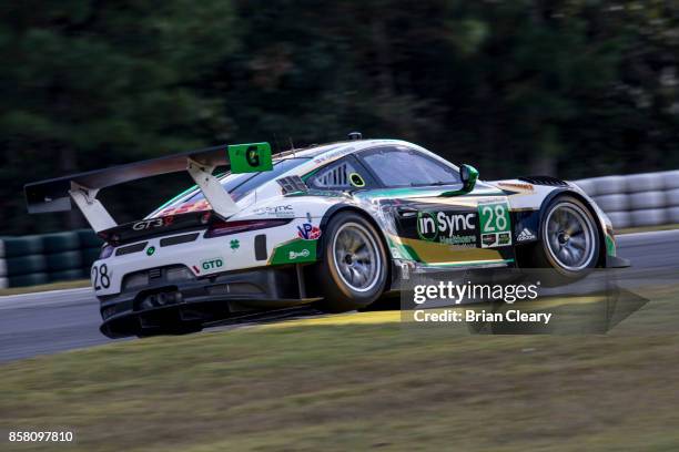 The Porsche of Daniel Morad, of Canada, Michael Christensen, of Denmark, and Michael de Quesada, drives on the track during practice at Road Atlanta...