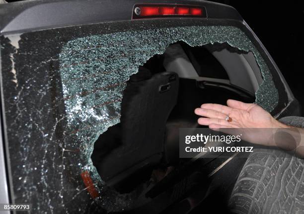 Man shows a smashed bullet found inside the car used by AFP photographer Yuri Cortez and local photographer Carlos Aviles during the covering of the...