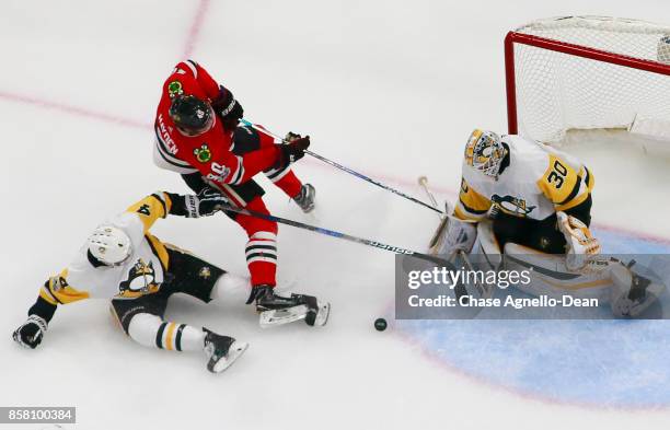 John Hayden of the Chicago Blackhawks and Justin Schultz of the Pittsburgh Penguins work to get the puck in front of goalie Matt Murray at the United...