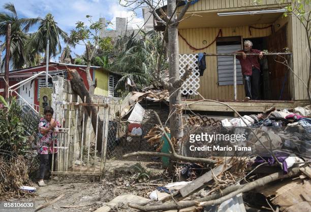 Residents Rosa and Errol gather at their damaged home without power or running water about two weeks after Hurricane Maria swept through the island...