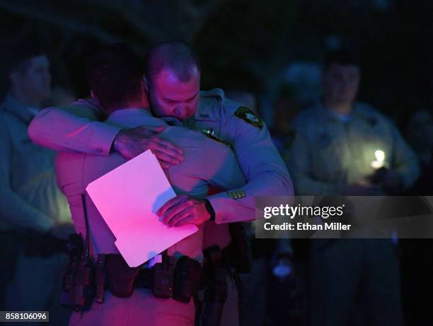 Las Vegas Metropolitan Police Department Sgt. Chris Dennis hugs LVMPD Officer Paul Wojcik as they speak during a vigil for Las Vegas Metropolitan...