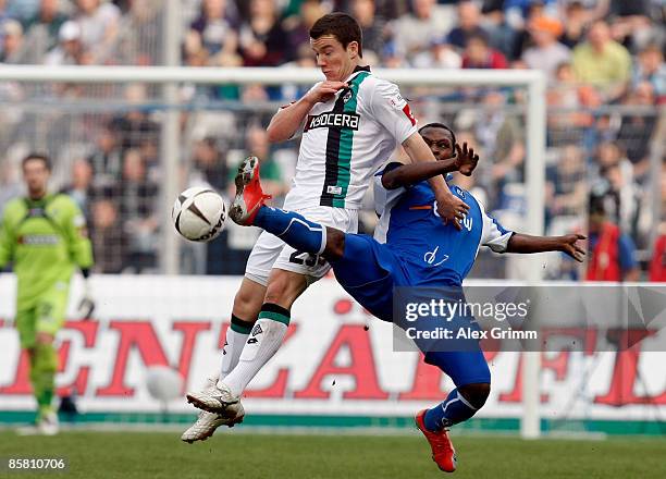 Alexander Baumjohann of Moenchengladbach challenges Godfried Aduobe of Karlsruhe during the Bundesliga match between Karlsruher SC and Borussia...