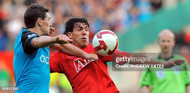 Manchester United's Argentinian forward Carlos Tevez vies with Aston Villa's English midfielder Gareth Barry during the English Premiership football...