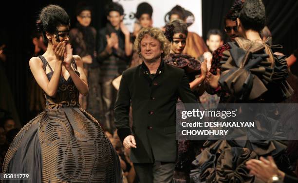 Indian designer Rohit Bal walks past models wearing his creations on April 5, 2009 during the grand finale of the Kolkata Fashion Week in Kolkata....