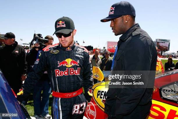 Brian Vickers , driver of the Red Bull Toyota, talks with running back Reggie Bush of the New Orleans Saints on the grid prior to the start of the...