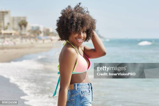 Pretty afro american girl holding hand on head smiling