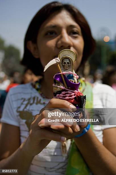 Devotee holds an image of the 'Santa Muerte' , at Tepito shantytown, in Mexico City, on April 5, 2009. The cult of this pseudo-religious skeletal...