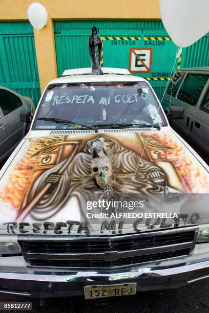 Car with the image of 'Santa Muerte' painted on its hood remains parked at Tepito shantytown, in Mexico City, on April 5, 2009. The cult of this...