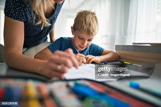 mother helping son to do his homework - kid handwriting stock pictures, royalty-free photos & images