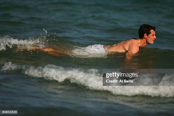 Andy Murray of Great Britain plays in the water during a photo shoot after defeating Novak Djokovic of Serbia to win the men's final of the Sony...