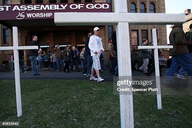 With 13 crosses representing the victims; people leave the First Assembly of God Church to make their way to the American Civic Association to pay...