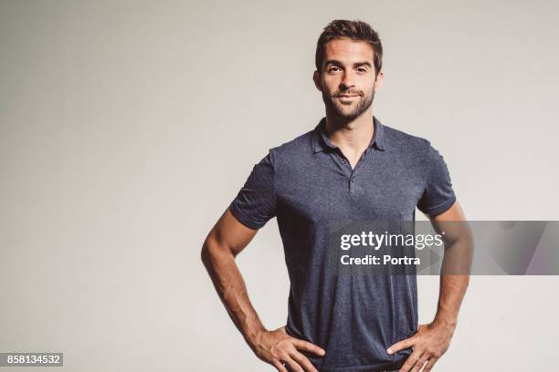 seguros mediados adulto hombre de pie con las manos en la cadera - mano sobre la cadera fotografías e imágenes de stock