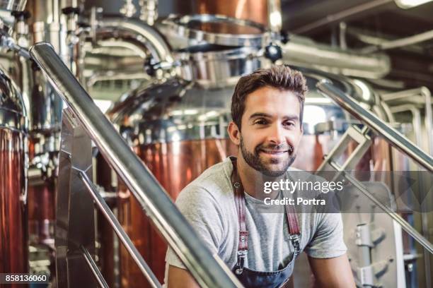 confident male owner sitting at microbrewery - distillery stock pictures, royalty-free photos & images