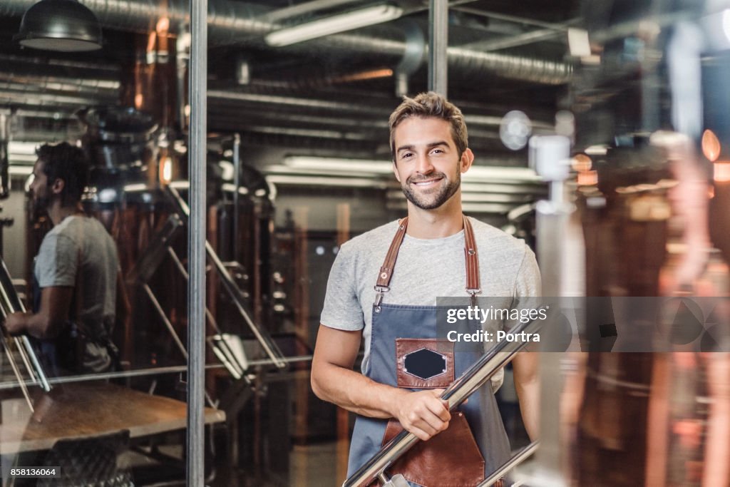 Confident smiling male manager standing by railing