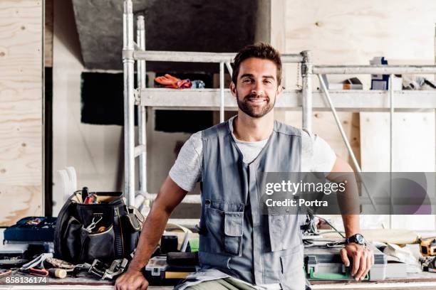 confident mid adult mechanic at auto repair shop - waistcoat stock pictures, royalty-free photos & images