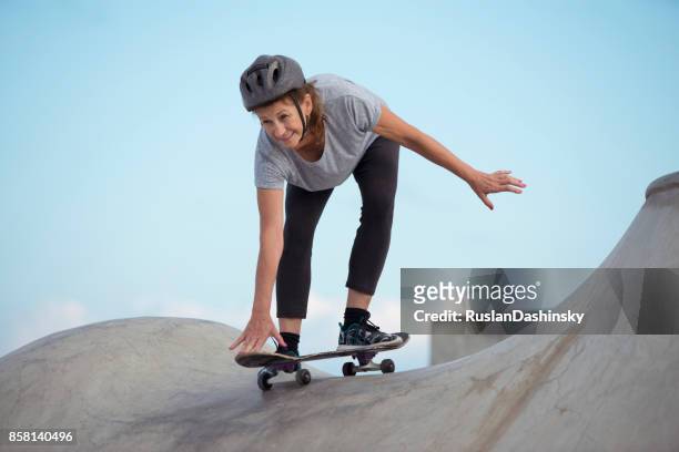 senior woman learning something new, doing extreme sport outdoors. - skateboarding half pipe stock pictures, royalty-free photos & images