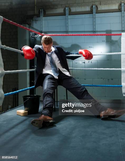 uomo d'affari eliminato in un angolo del box ring - mettere a tappeto foto e immagini stock